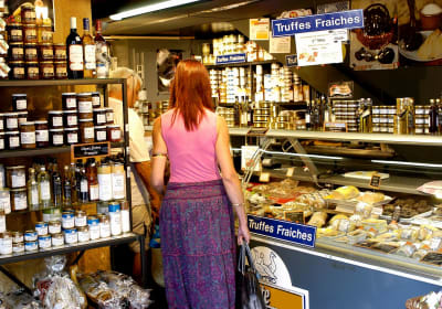Colourful market stalls in Sarlat displaying foie gras, black truffles, walnuts and local Périgord specialities in the Dordogne