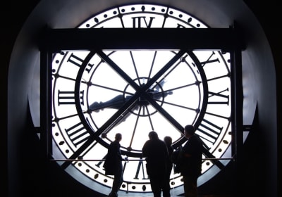 Visitors silhouetted against the large Musée d’Orsay clock during a museum visit