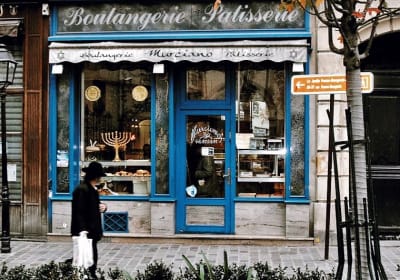 Blue bakery storefront with a menorah in the window in Le Marais