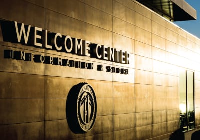 Welcome Center Information & Shop exterior with Golden Gate Bridge logo on tan-colored building facade