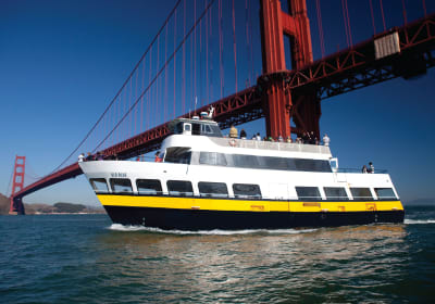 White and yellow ferry boat 'Old Blue' passing under the iconic Golden Gate Bridge in San Francisco Bay