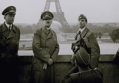 Black-and-white image of uniformed wartime figures with the Eiffel Tower behind them