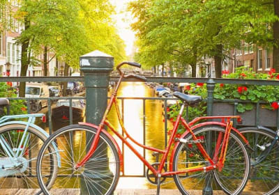 Red bicycle beside an Amsterdam canal