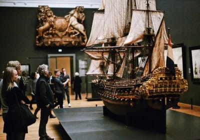 Visitors viewing a historic ship model inside the Rijksmuseum