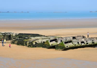 Concrete Mulberry Harbour caissons on the sand and in the sea at Arromanches-les-Bains