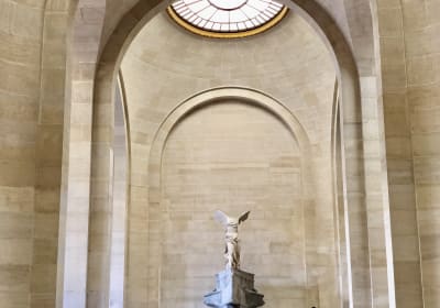 The Winged Victory of Samothrace in a tall Louvre stair hall