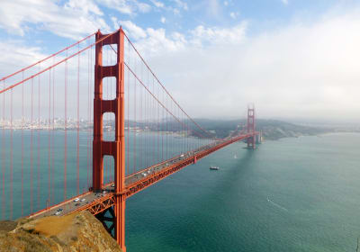 Golden Gate Bridge spanning San Francisco Bay with city skyline and Marin Headlands visible
