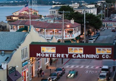 Monterey Canning Co. building at dusk with waterfront shops and bay views in Monterey, California