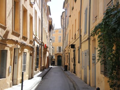 Quiet narrow street lined with pastel townhouses in Aix-en-Provence