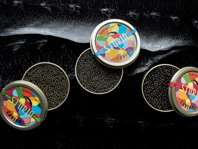 Small tins of caviar on a tasting board