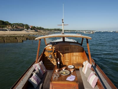 Wooden pinasse boat with cushions and seafood platter cruising on Arcachon Bay