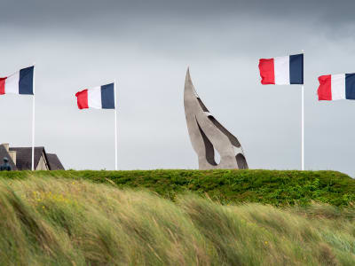 Sword Beach shoreline with the Bill Millin Monument in the foreground