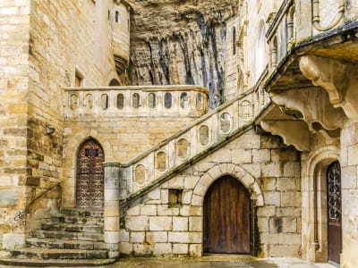 Stone staircase and arched doors built into the cliff at the sanctuary of Rocamadour in southwest France