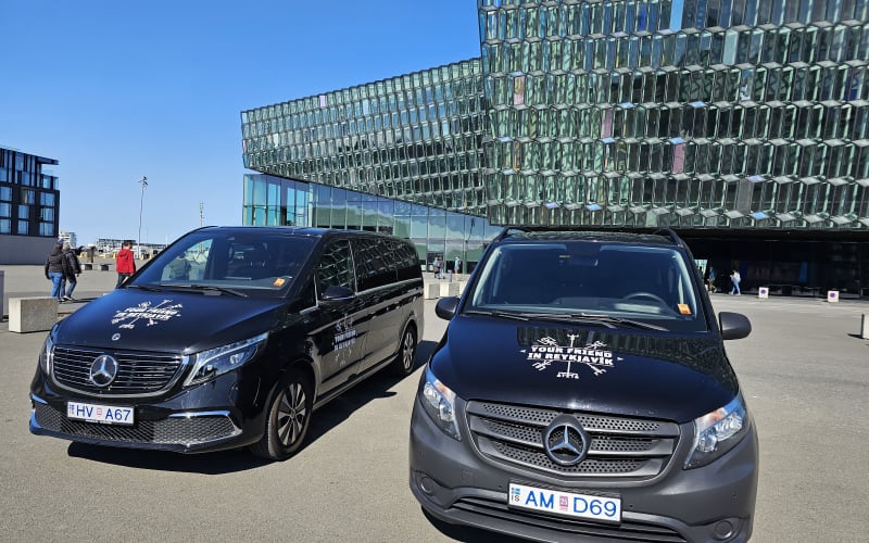 Two two vehicles parked with the "Your Friend in Reykjavik" logo on the hood of the car. 