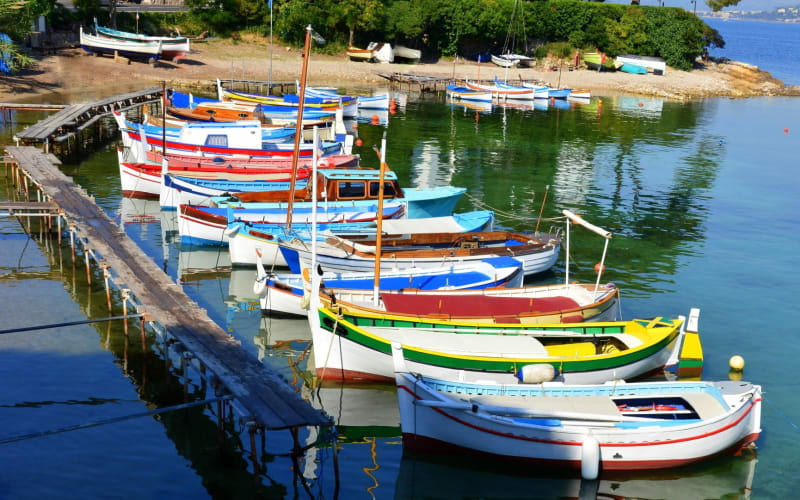 Colourful traditional fishing boats moored in a calm harbour near Antibes on the French Riviera.
