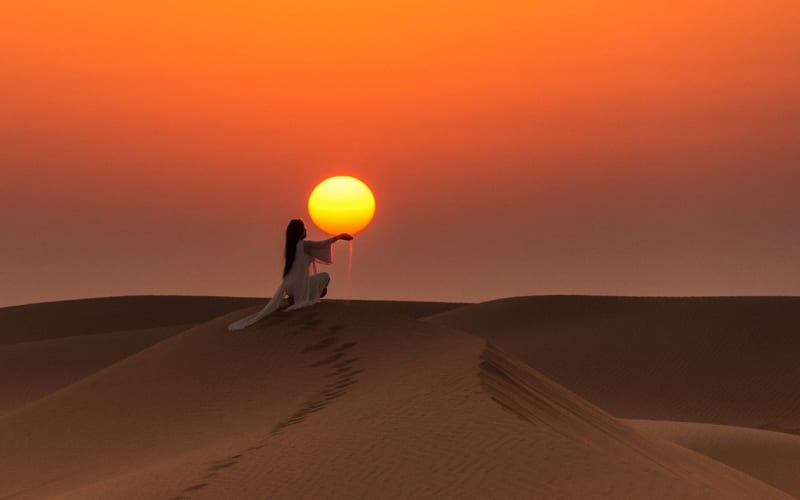 A woman dping pictures with the sun during the 5 day Morocco tour from Rabat.