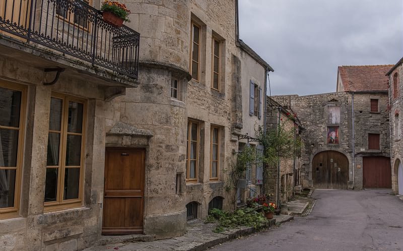  Stone houses and a narrow cobbled street in the medieval village of Flavigny‑sur‑Ozerain in Burgundy, France.