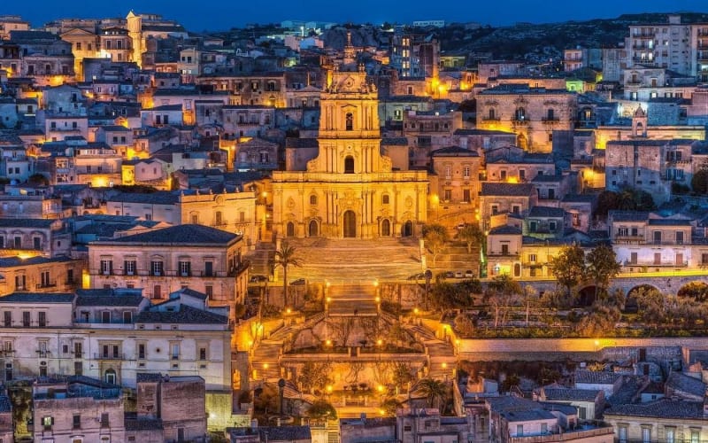 The baroque Cathedral of San Giorgio and the old town of Modica illuminated at night