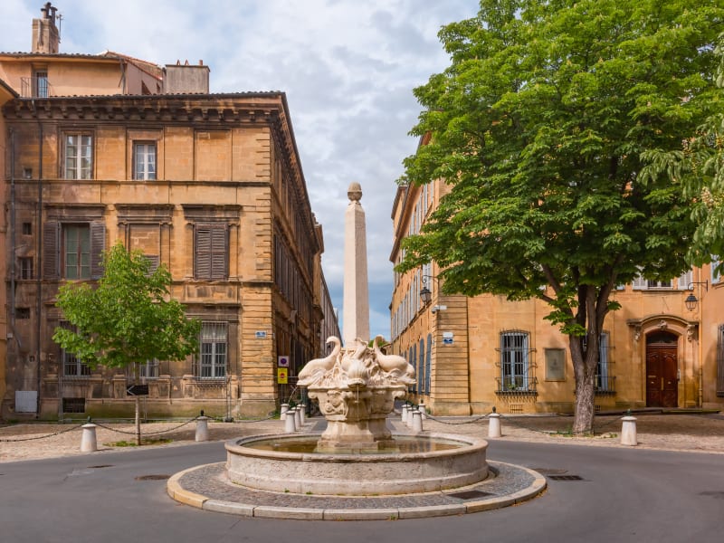 Stone fountain in small square surrounded by historic mansions in Aix-en-Provence
