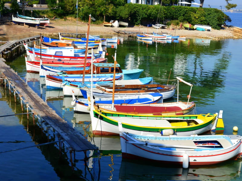 Colourful traditional fishing boats moored in a calm harbour near Antibes on the French Riviera.