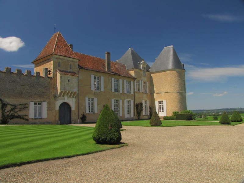 Exterior view of Château d'Yquem surrounded by vineyards in the Sauternes region near Bordeaux