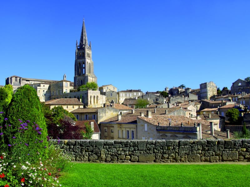 Panoramic view of Saint-Émilion UNESCO village golden limestone buildings with iconic bell tower surrounded by vineyards