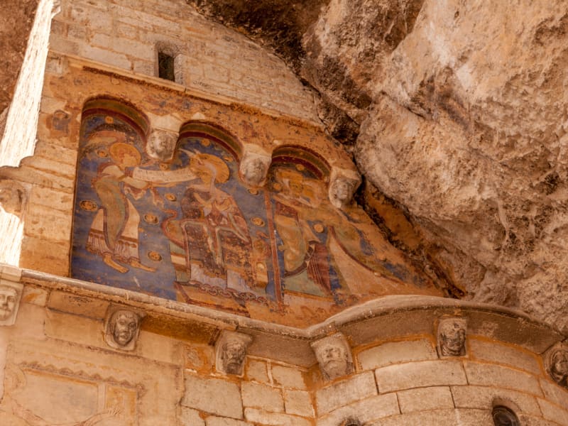 Detail of colorful medieval religious frescoes painted on the stone wall of a sanctuary in Rocamadour, carved directly into the cliffside in southwest France