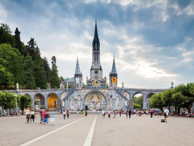 Panoramic view of the Sanctuary of Our Lady of Lourdes with the Basilica of the Immaculate Conception rising above the Gave de Pau river in the Hautes-Pyrénées