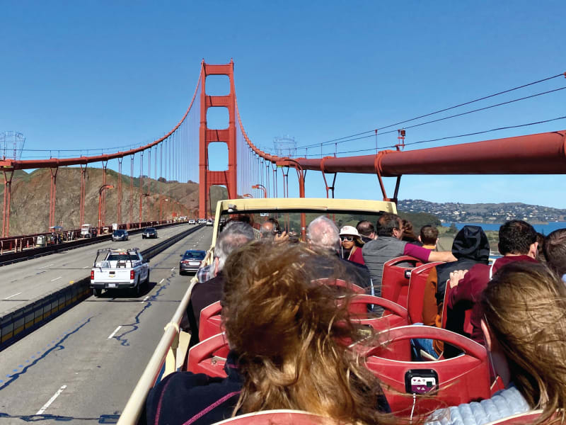 Tourist bus crossing the Golden Gate Bridge in San Francisco with passengers enjoying the view