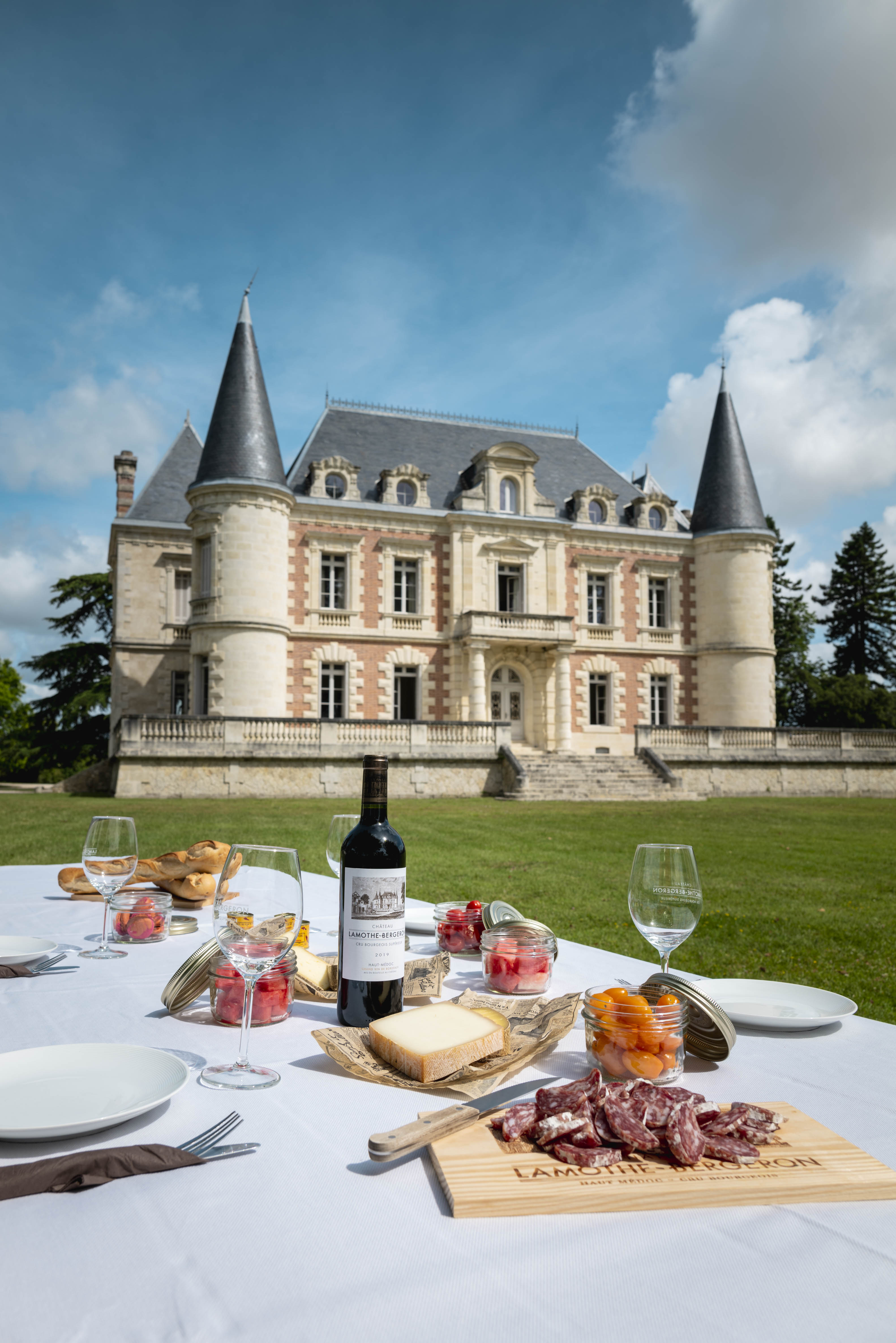 Elegant picnic setup with French charcuterie, cheese, and wine in Château Lamothe Bergeron vineyard gardens