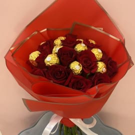 Red Roses with Ferrero Rocher topping in an elegant orange sheet tied with white ribbon