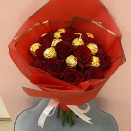 Red Roses with Ferrero Rocher topping in an elegant orange sheet tied with white ribbon