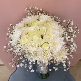 A pageant Bouquet of White Roses, Chrysanthemum, and Gypsophila filling.  