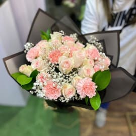 Bouquet of Pink roses and carnation with baby's breath and Eucalyptus filling in black wrapping.