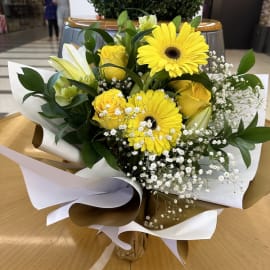 Angled view of the Golden Radiance bouquet, revealing its luxurious golden and white double color wrapping