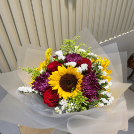 A beautiful Boquete flower arrangement featuring sunflower, solidago, red rose, purple chrysanthemum, and white wax, with warm and inviting tones evoking feelings of love, happiness, and elegance.