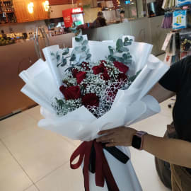 A romantic bouquet featuring 17 red roses, eucalyptus, and baby's breath, symbolizing love and purity.