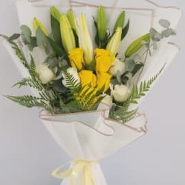 Condolence bouquet featuring lilies and roses