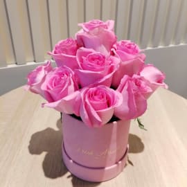 Close-up of 13 pink roses in a pink velvet box