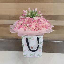  A lush bouquet with 100 light pink roses and 20 vibrant pink tulips.