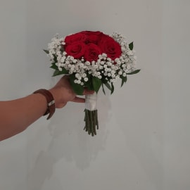 Classic wedding bouquet featuring red roses and baby breath.
