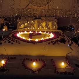 Golden theme bed. On bed there is flowers and candles