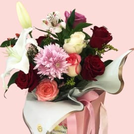 In a lovely pink box, red and pink roses with white lily, alstroemeria, chrysanthemum, and solidago.