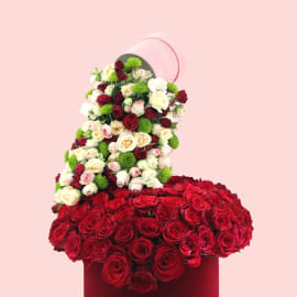 Luxurious red rose arrangement in a red velvet hatbox.