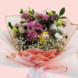 Full floral arrangement showing mix of white daisies, pink carnations, Eustoma, and purple chrysanthemums with playful sheep accents.

