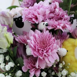 Front-facing view of entire bouquet with white ribbon, colorful flowers, and cheerful handmade sheep for decorative charm.