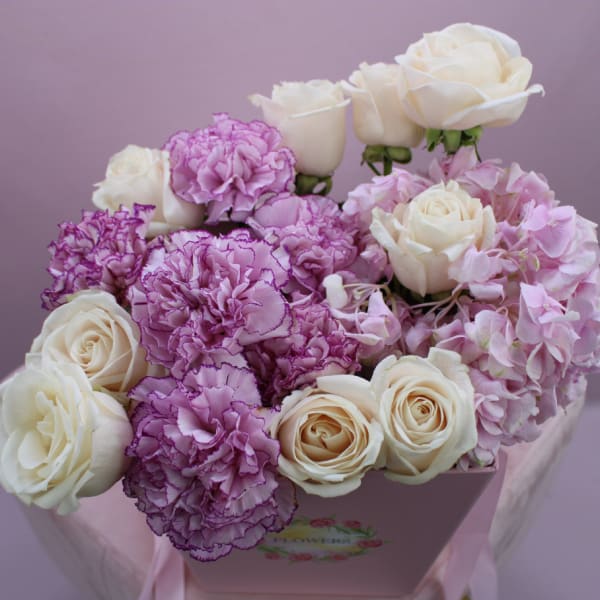 Peach roses and purple carnation in bucket 