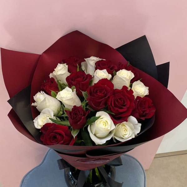 Red and White Roses bouquet wrapped in an elegant red Sheet.