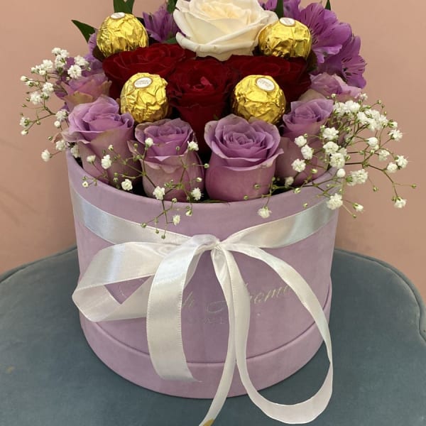 This beautiful and delicate arrangement contains purple roses surrounded by purple alstroemeria and red roses and a White rose in the middle with baby's breath filling and Ferrero Rocher chocolate bal