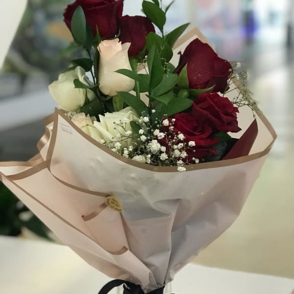 Bouquet of red and white roses with baby's breath filling. 